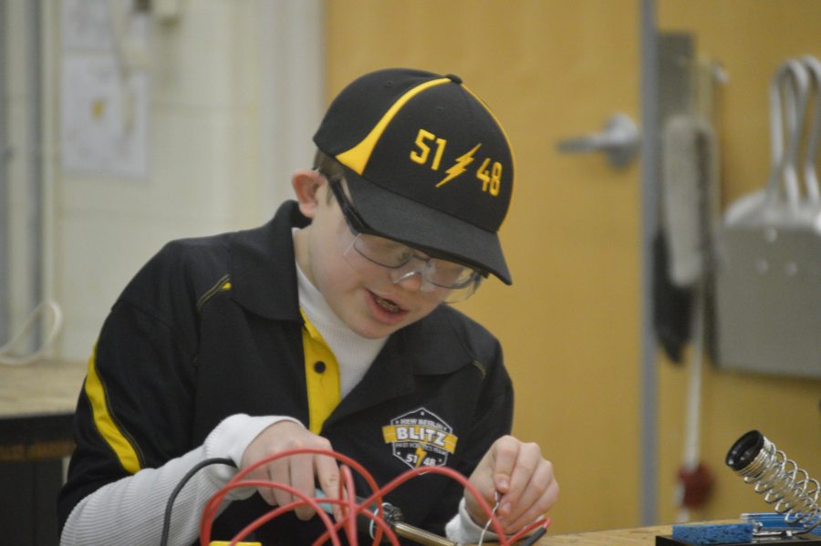 Mason Primus, demonstrating how to solder two wires together at the STEM fair