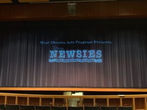 The newsies logo before the opening of the curtain for the first scene.
